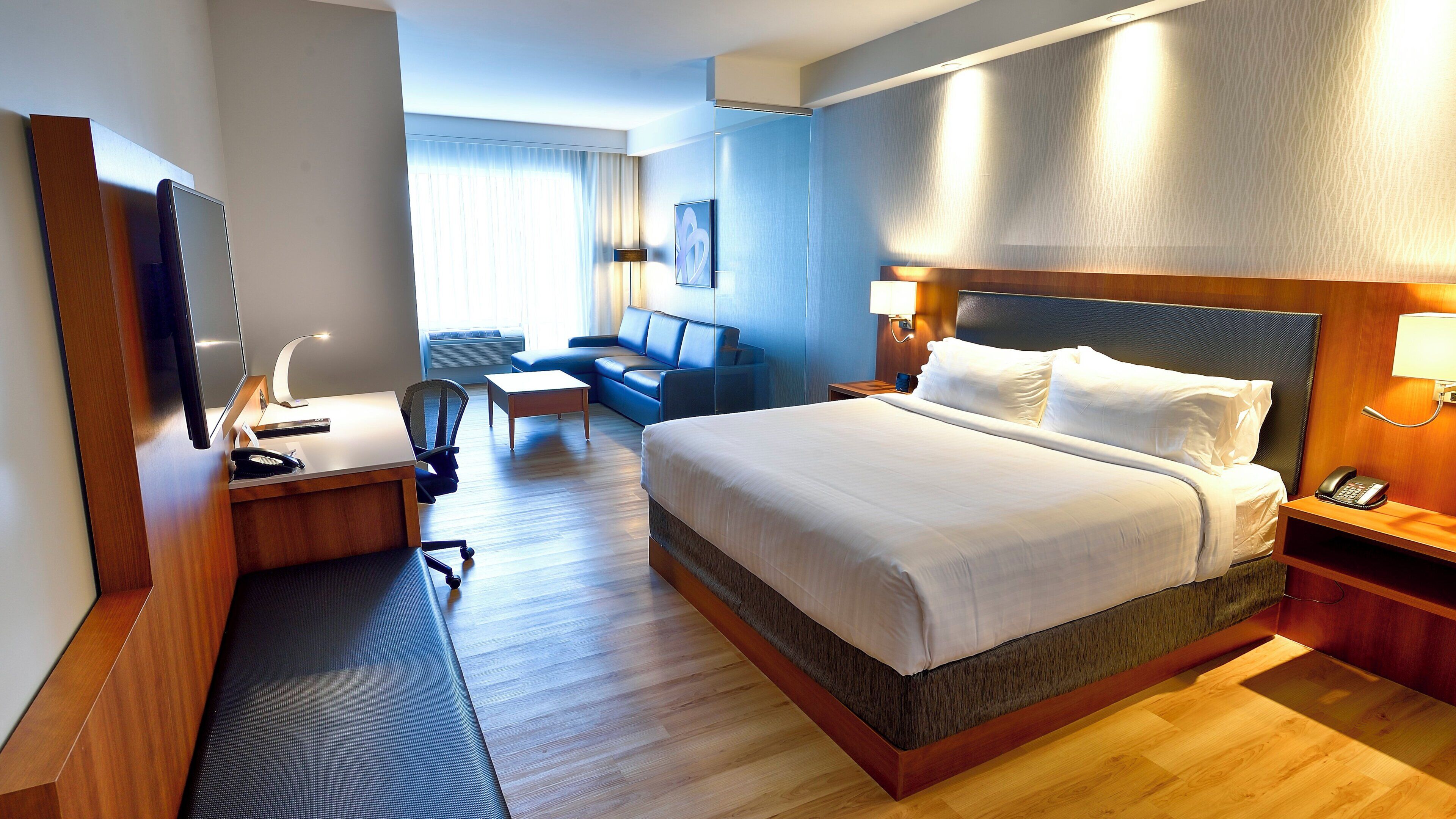 Une chambre d’hôtel équipée d’un lit, d’un bureau, d’une chaise et d’un téléviseur.