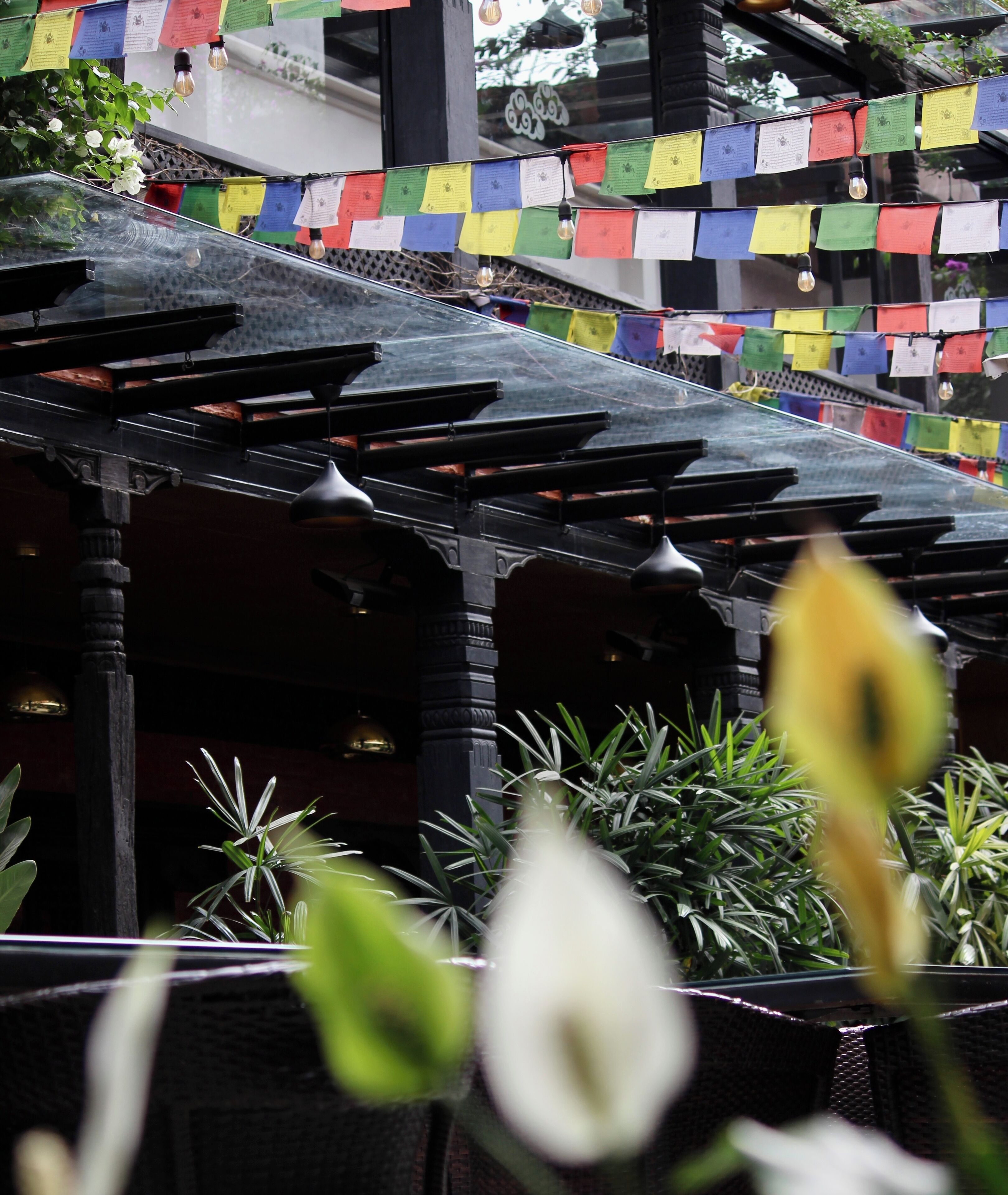 A traditional building with a covered walkway and colorful prayer flags.