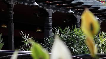 A traditional building with a covered walkway and colorful prayer flags.