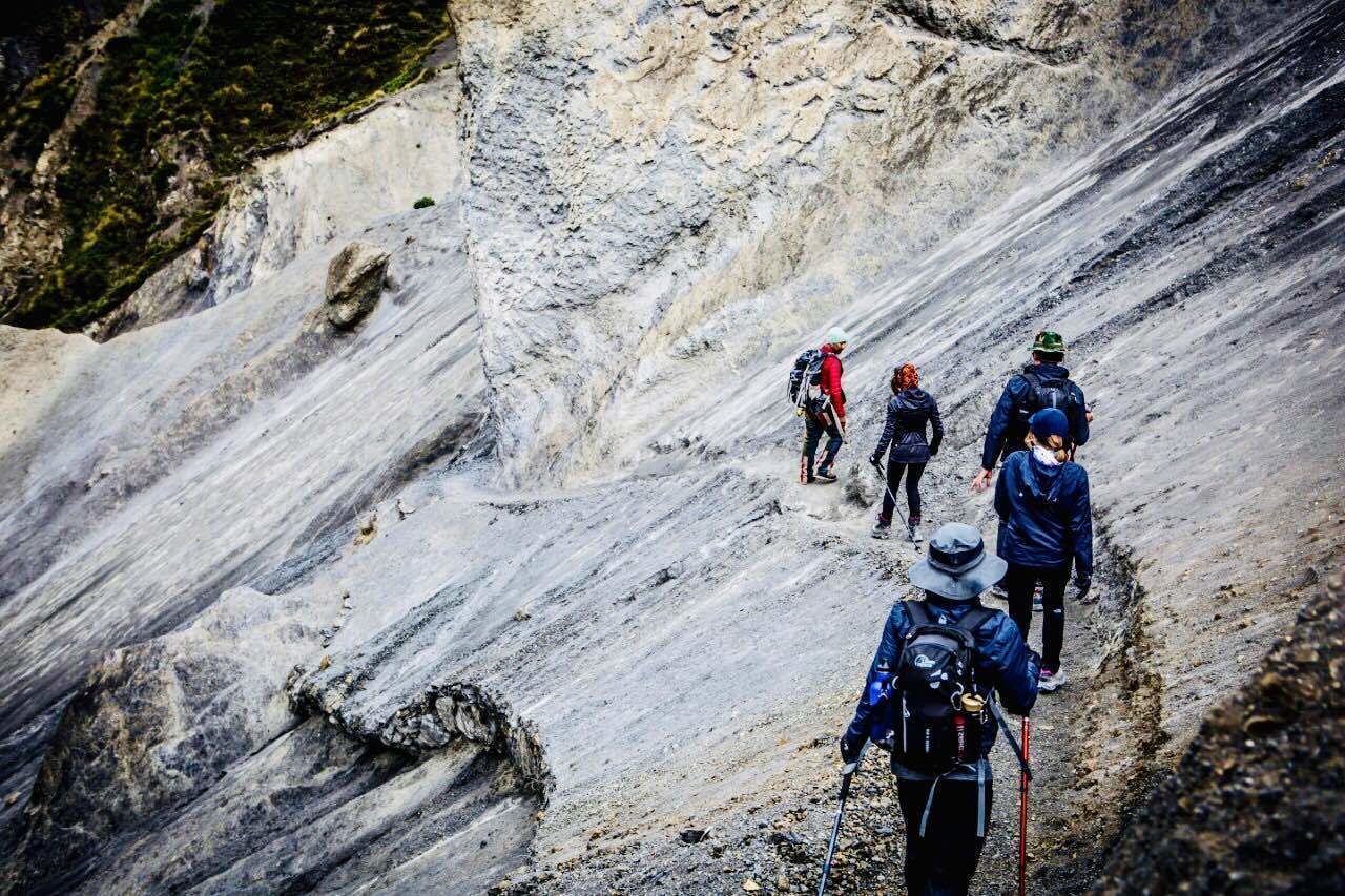 A group of hikers on a rocky mountain trail.