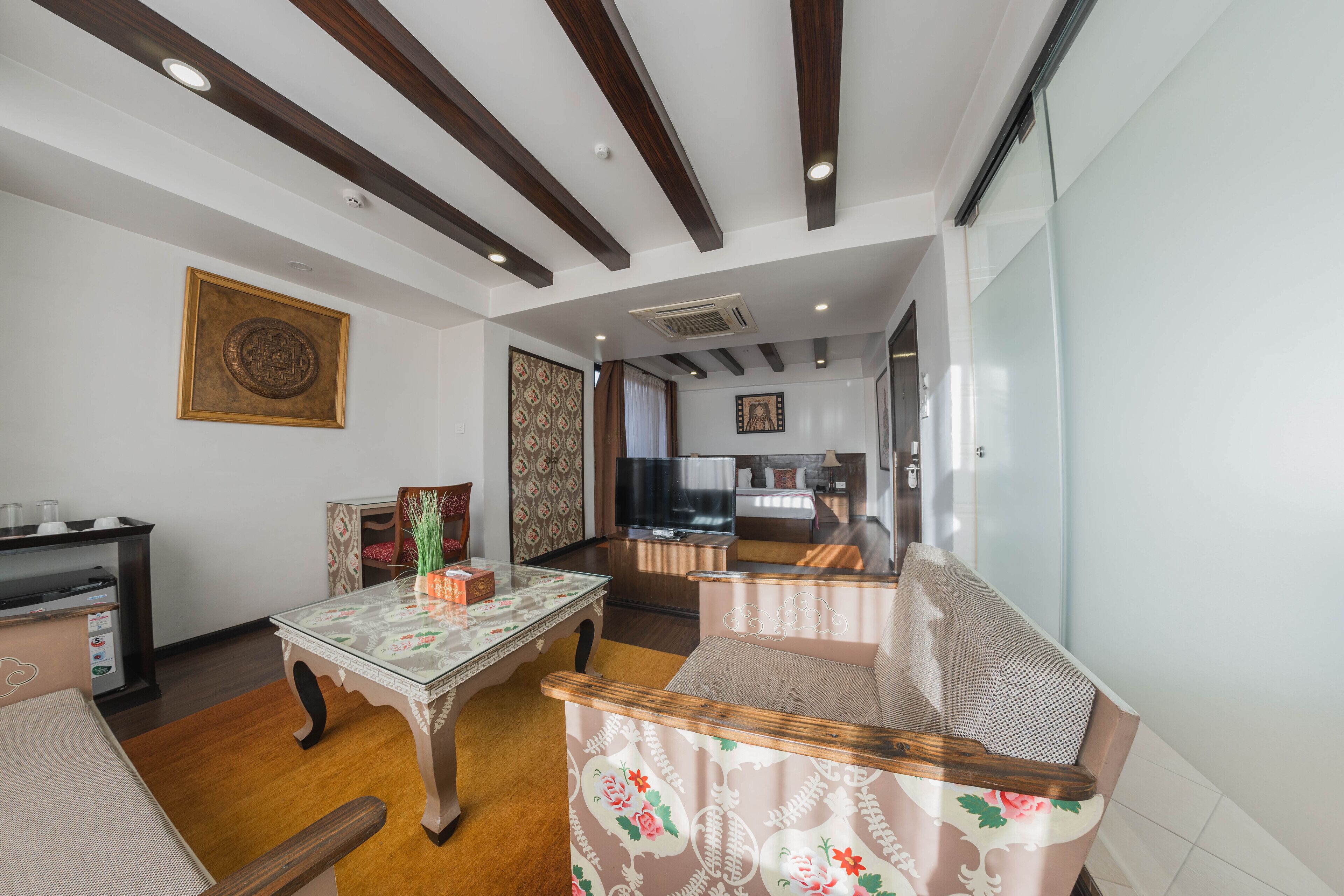 A living room with a sofa, a coffee table, and a television in the background.