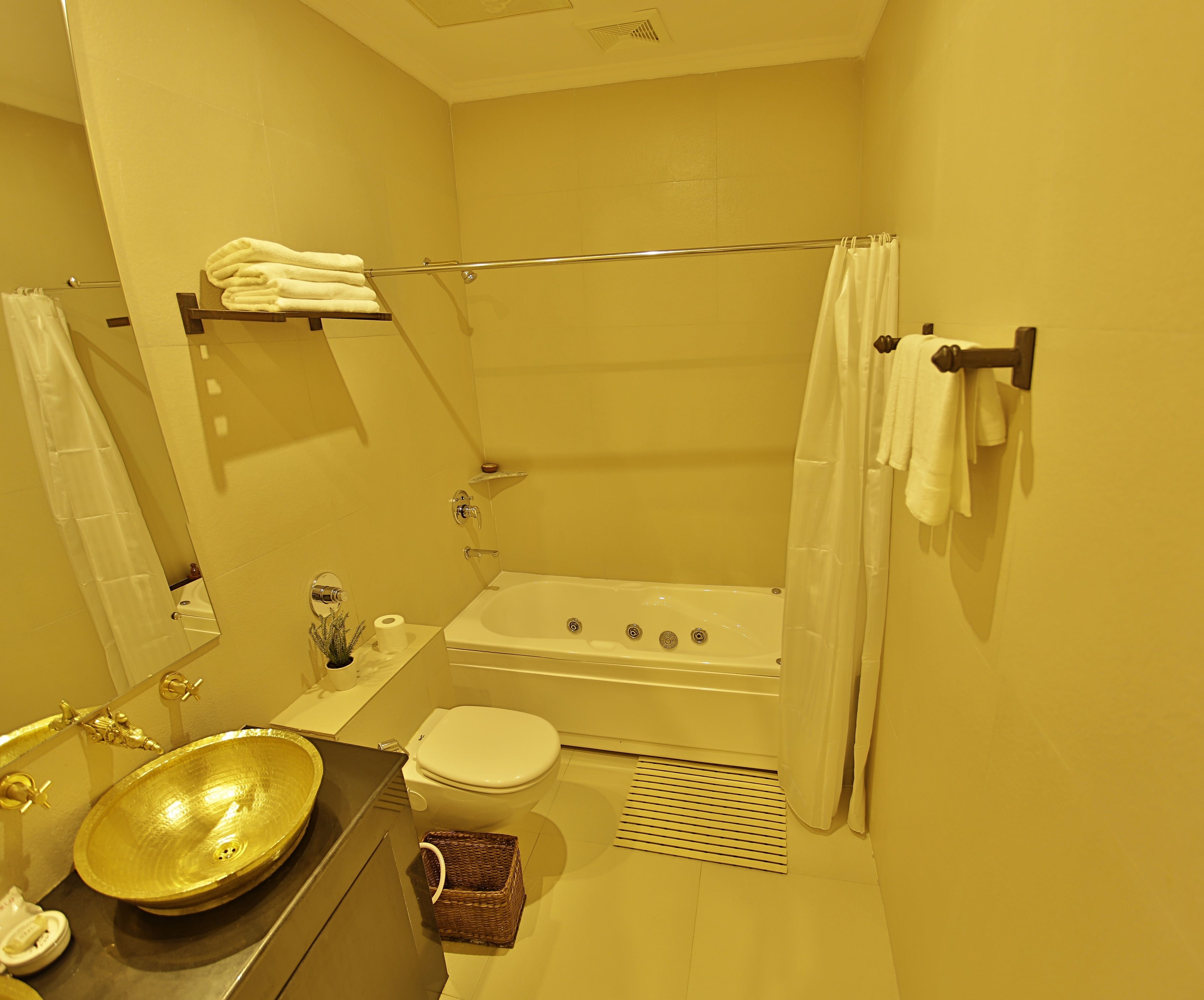 A bathroom with a bathtub, toilet, sink, and a mirror.