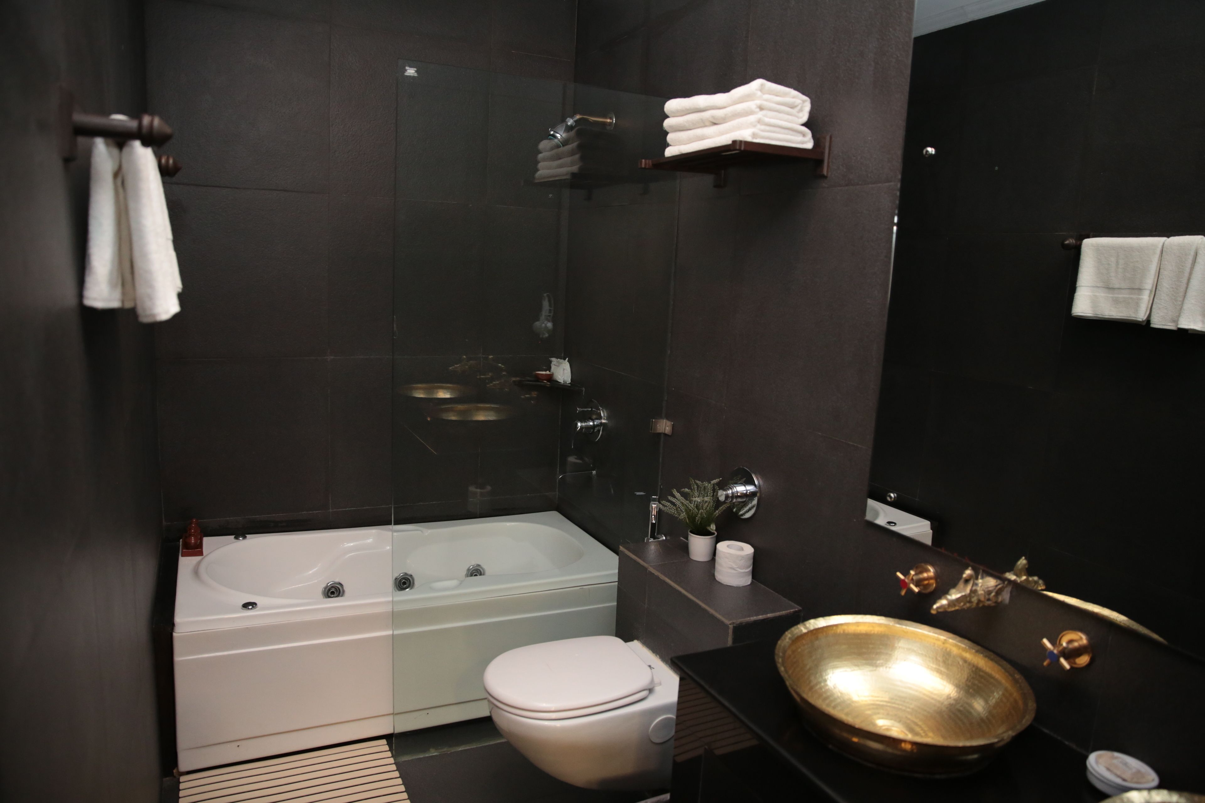 Un baño moderno con bañera, inodoro y un lavamanos grande.