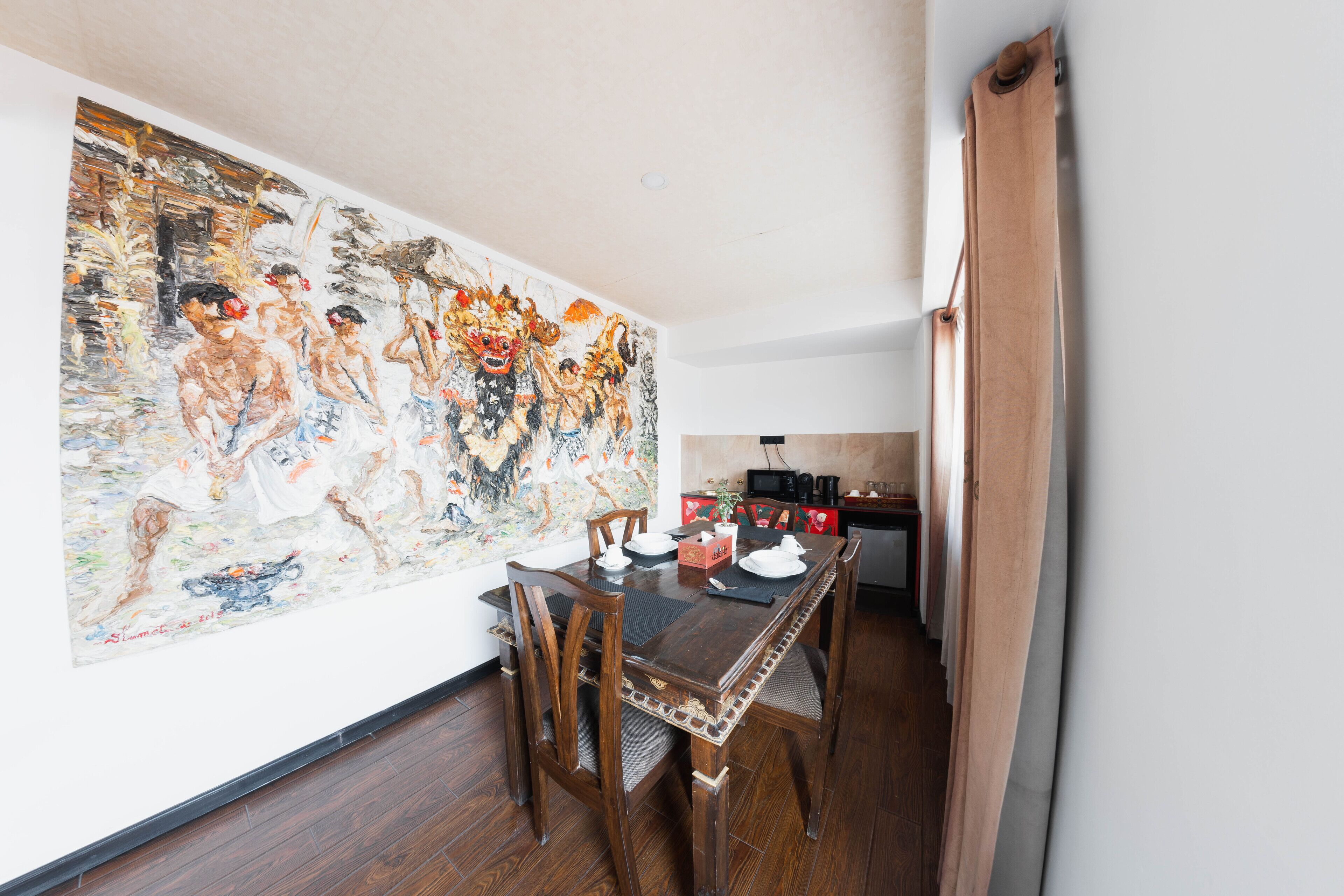A dining area with a wooden table, chairs, and a large painting on the wall.
