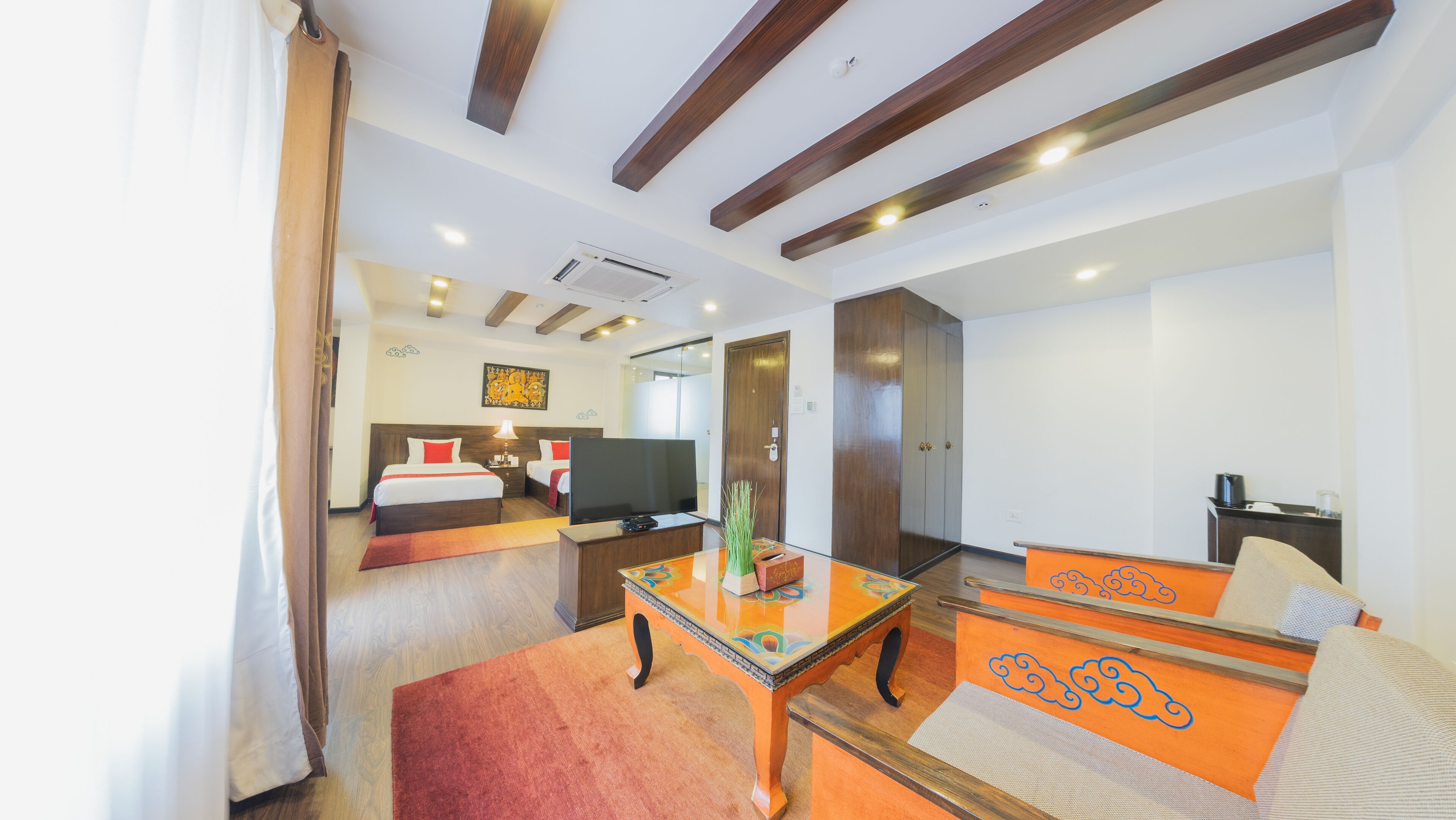 Una habitación de hotel con cama, televisor, escritorio y sofá.