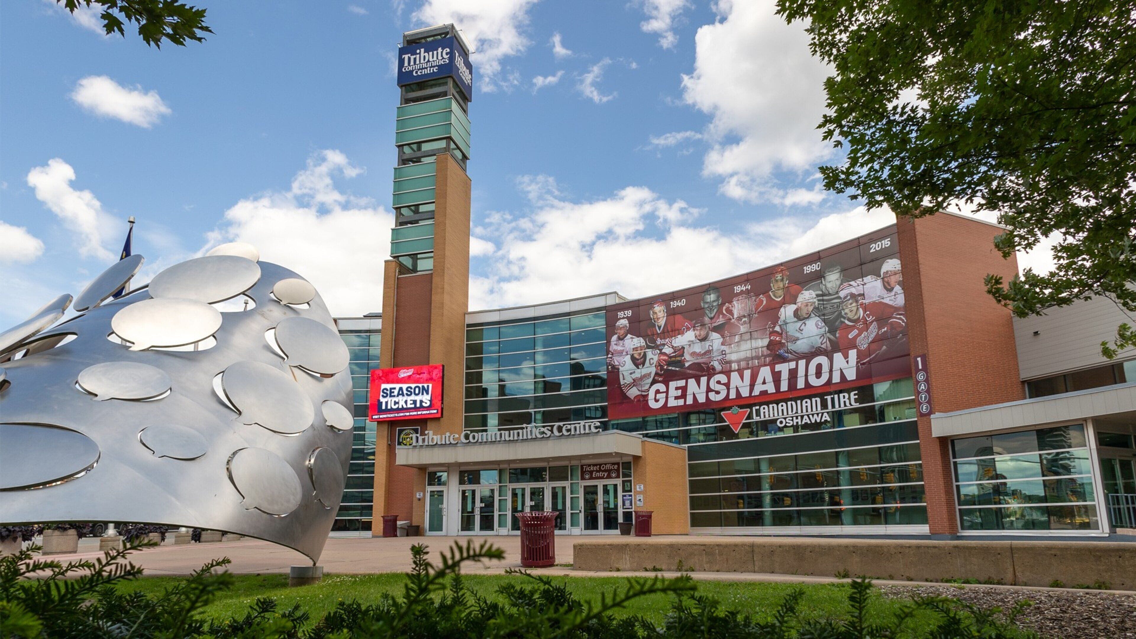 A Tribute Communities Centre with a large hockey-themed mural, a ticket office, and a distinctive metallic sculpture.