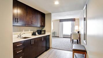 A modern kitchen with dark cabinets, a sink, and a microwave.