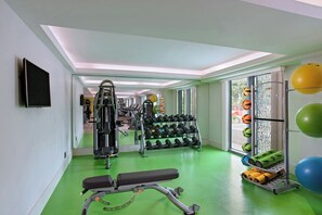 A gym with exercise equipment, a bench, dumbbells, and exercise balls. - Marriott Port-au-Prince Hotel (Port-au-Prince)