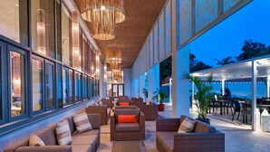 A spacious outdoor seating area with wicker furniture and a view of the ocean.