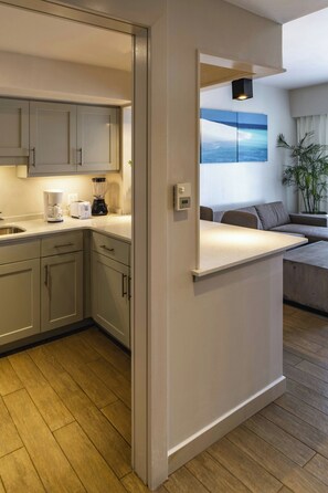 A modern kitchen with light wood cabinets, a built-in island, and a coffee maker. - Marriott Port-au-Prince Hotel (Port-au-Prince)