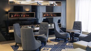 A modern lounge area with sofas, a coffee table, and a fireplace. - Mercure Edinburgh Haymarket (Edinburgh)