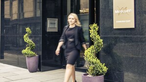 The exterior of the Mercure Hotel in Edinburgh, featuring a modern facade, large potted plants, and a clear entrance. - Mercure Edinburgh Haymarket (Edinburgh)