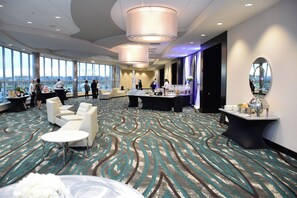 A spacious hotel lobby with a large seating area, a reception desk, and a view of the city through large windows. - Holiday Inn Cincinnati N - West Chester by IHG (West Chester)