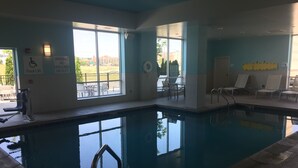An indoor swimming pool with clear windows, a lifeguard chair, and a pool lift. - Holiday Inn Cincinnati N - West Chester by IHG (West Chester)