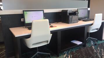 A modern office space with two desks, each with a computer and a chair.
