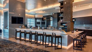 Una cocina moderna con una isla central, taburetes de bar y electrodomésticos integrados.