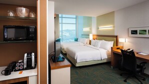 A hotel room with a bed, desk, microwave, coffee maker, and a view of the city. - SpringHill Suites by Marriott Kennewick Tri-Cities (Kennewick)