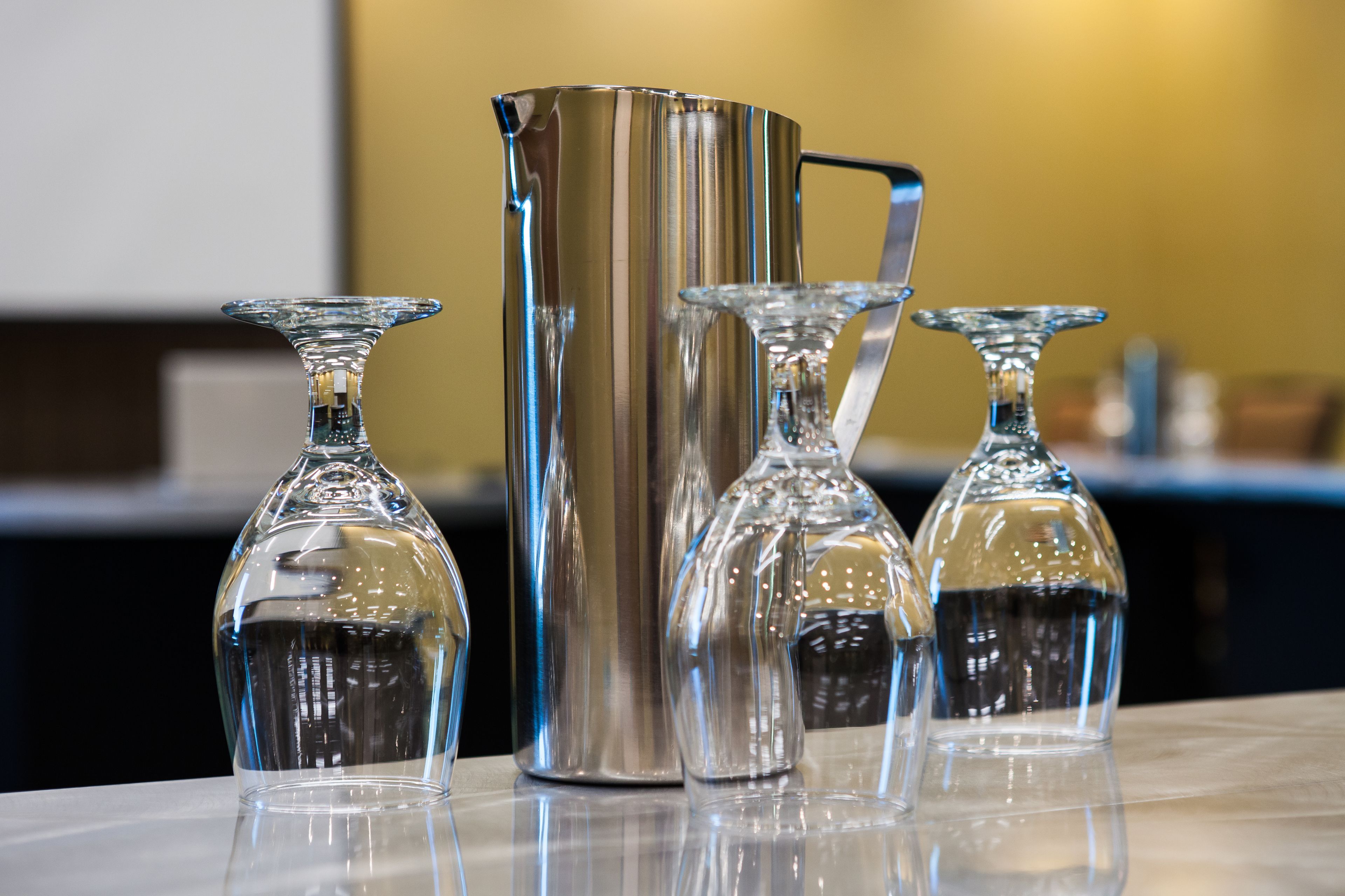 A set of four glass decanters on a reflective surface.