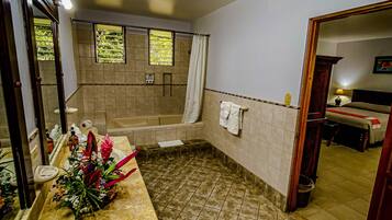 Une salle de bain équipée d’un lavabo, d’un miroir, d’une douche et d’une baignoire.