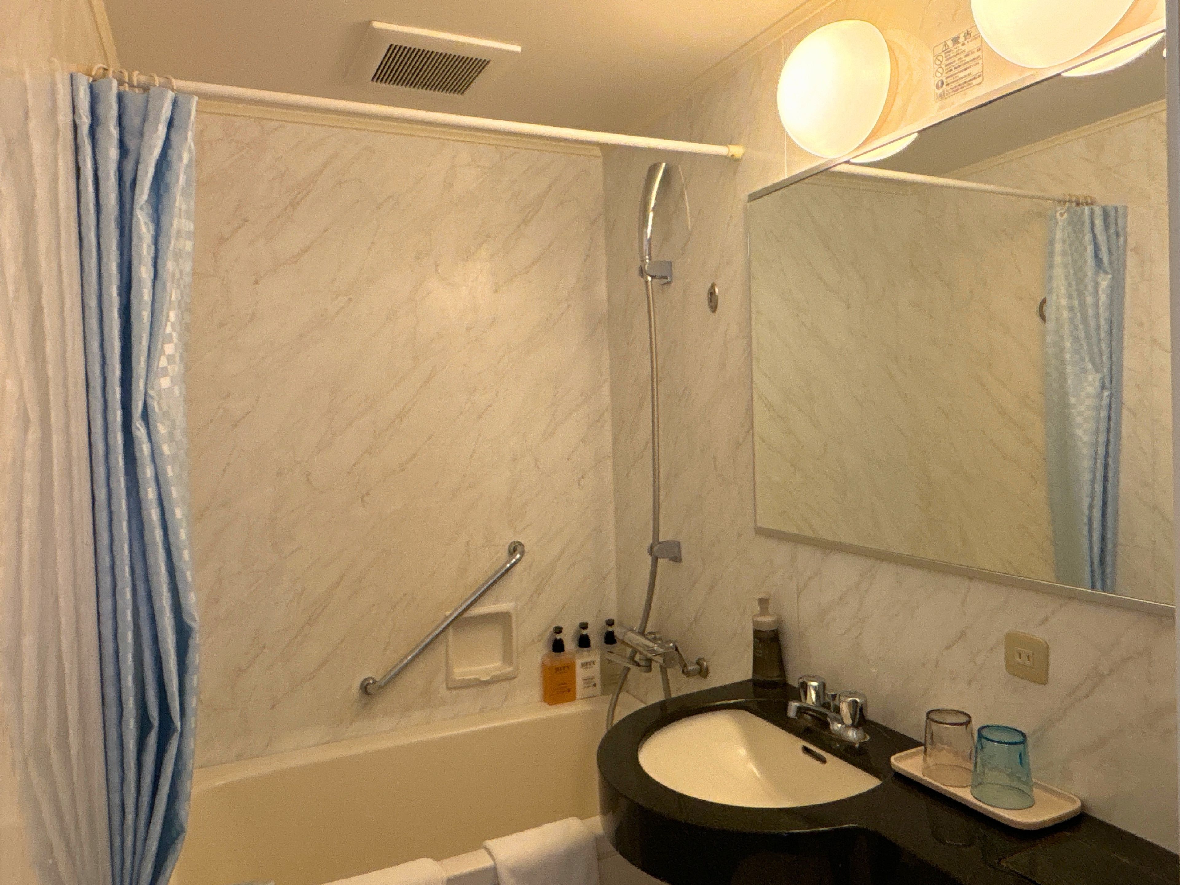 Ein Badezimmer mit Badewanne, Waschbecken, Spiegel und Dusche.