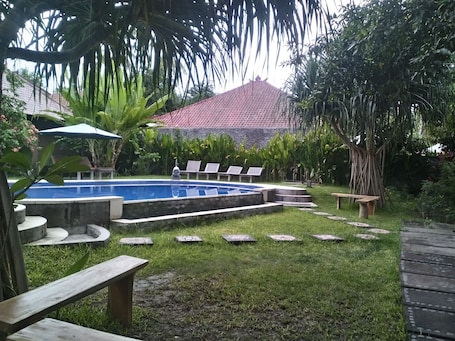 Una piscina al aire libre, sillones reclinables de piscina