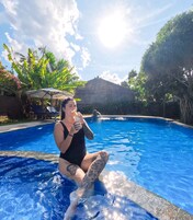 Una piscina al aire libre, sillones reclinables de piscina