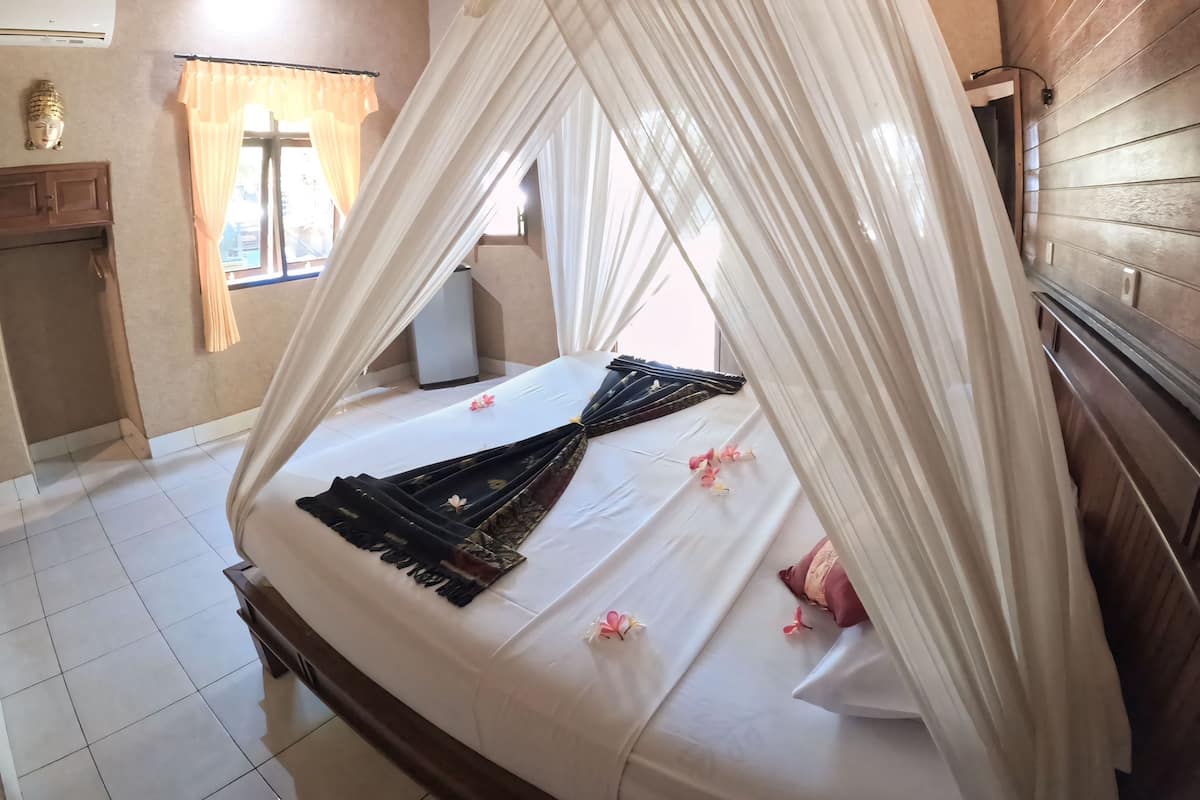 Ein Zimmer mit einem Himmelsbett, einem kleinen Tisch und einem fensterbepflanzten Fenster.