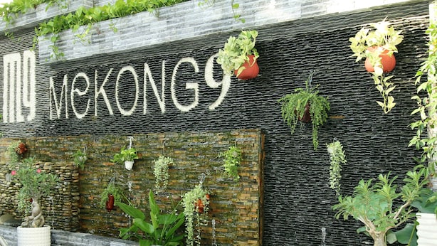 A building facade with the name "Mekong9" in large letters, surrounded by various potted plants and greenery.