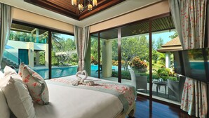 A hotel room with a large bed, a TV, and a view of a swimming pool and greenery.