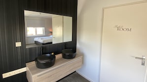 A bathroom with a large mirror, two black sinks, a wooden vanity, and a door labeled "Bath Room". - Hotel Café Restaurant Dallinga (Sluiskil)