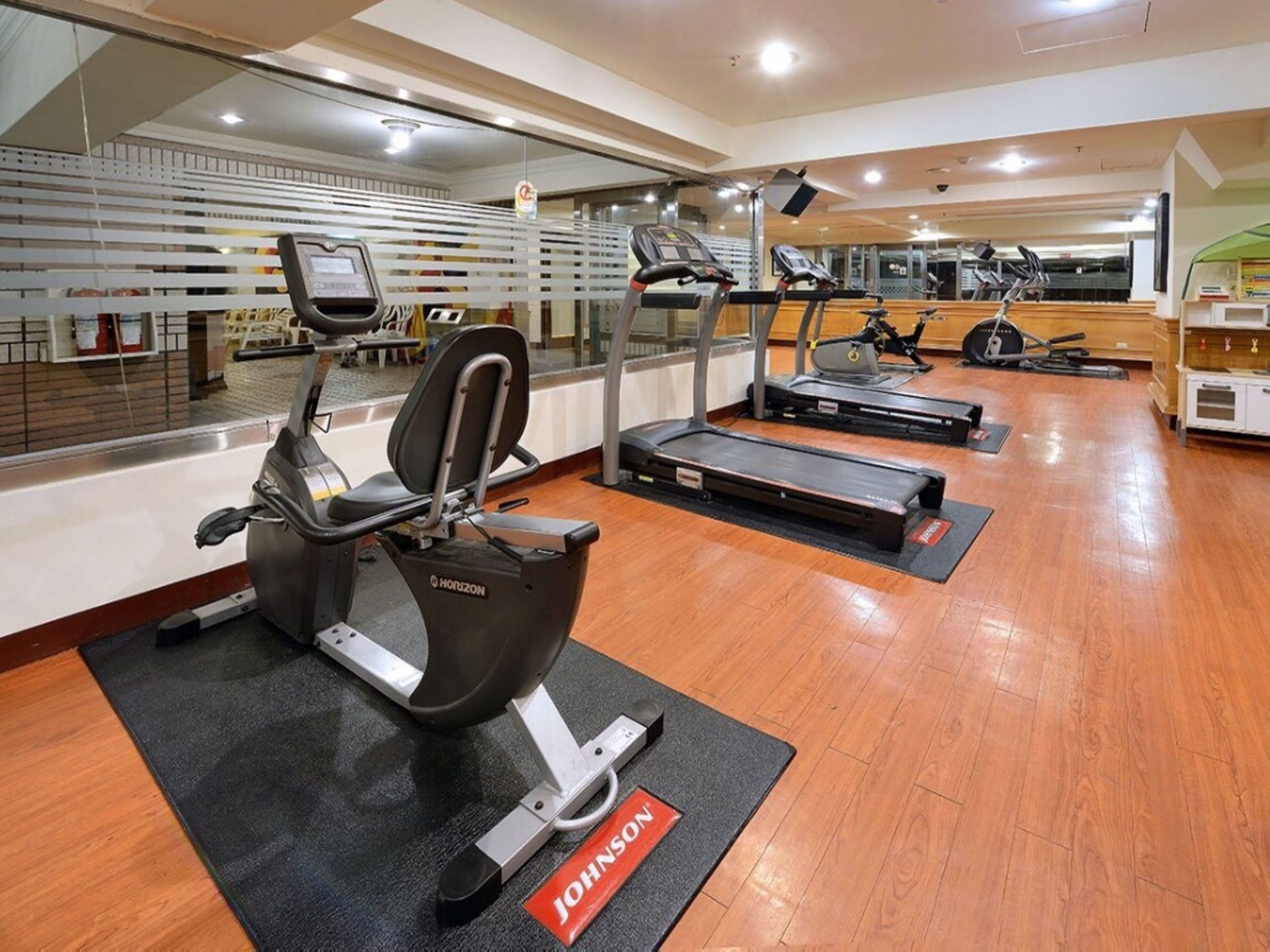 A gym with treadmills, stationary bikes, and a rowing machine.