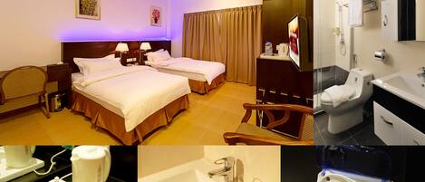 A hotel room with two beds, a bathroom with a sink and toilet, and a breakfast tray with coffee and tea.