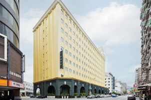 Un hotel de varios pisos con fachada amarilla y varias ventanas.