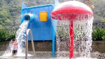 Kids can splash and play in the water feature with a mushroom-shaped spout and a play structure.