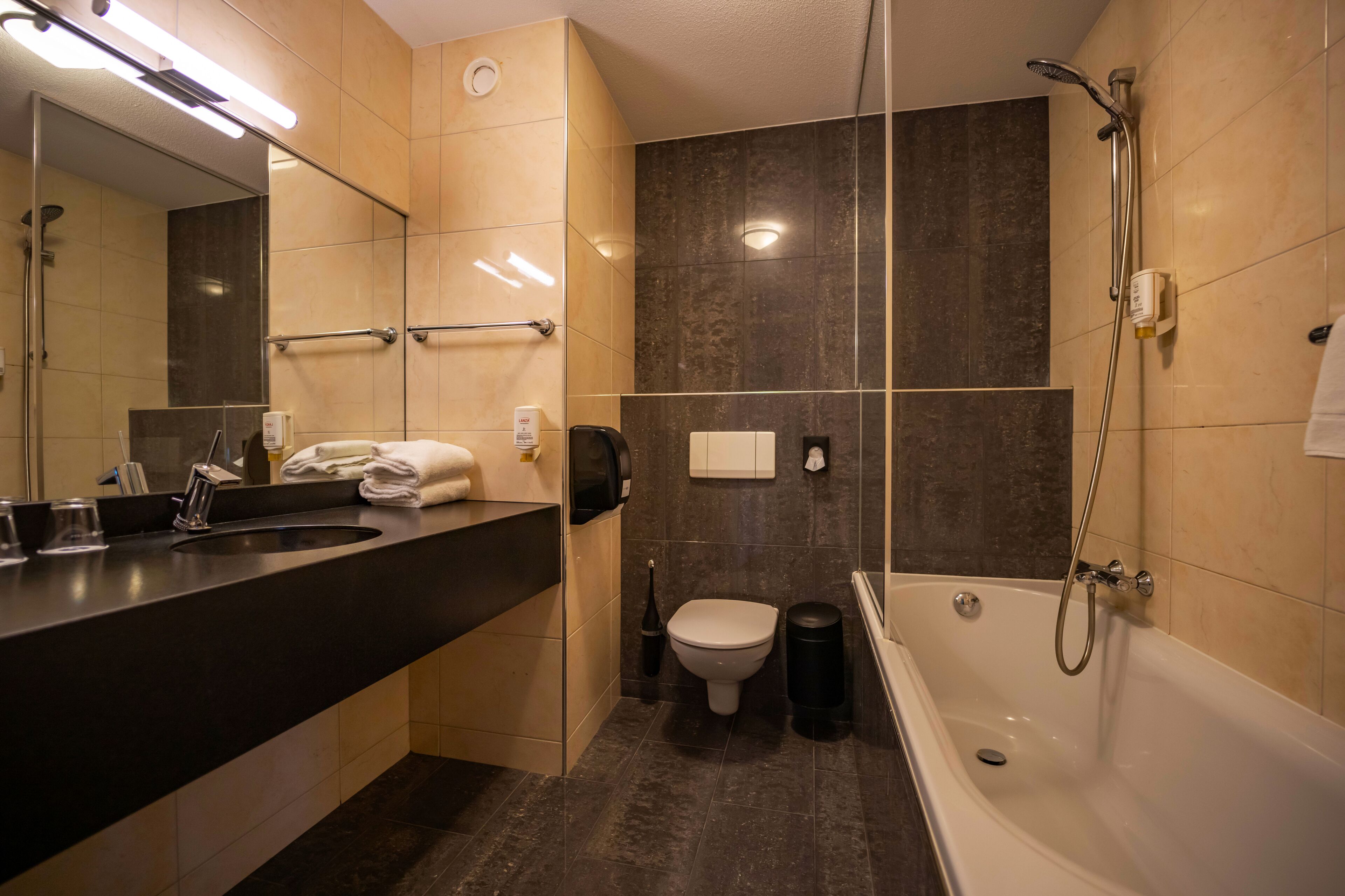 A modern bathroom with a bathtub, a toilet, and a sink.