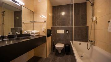 A modern bathroom with a bathtub, a toilet, and a sink.