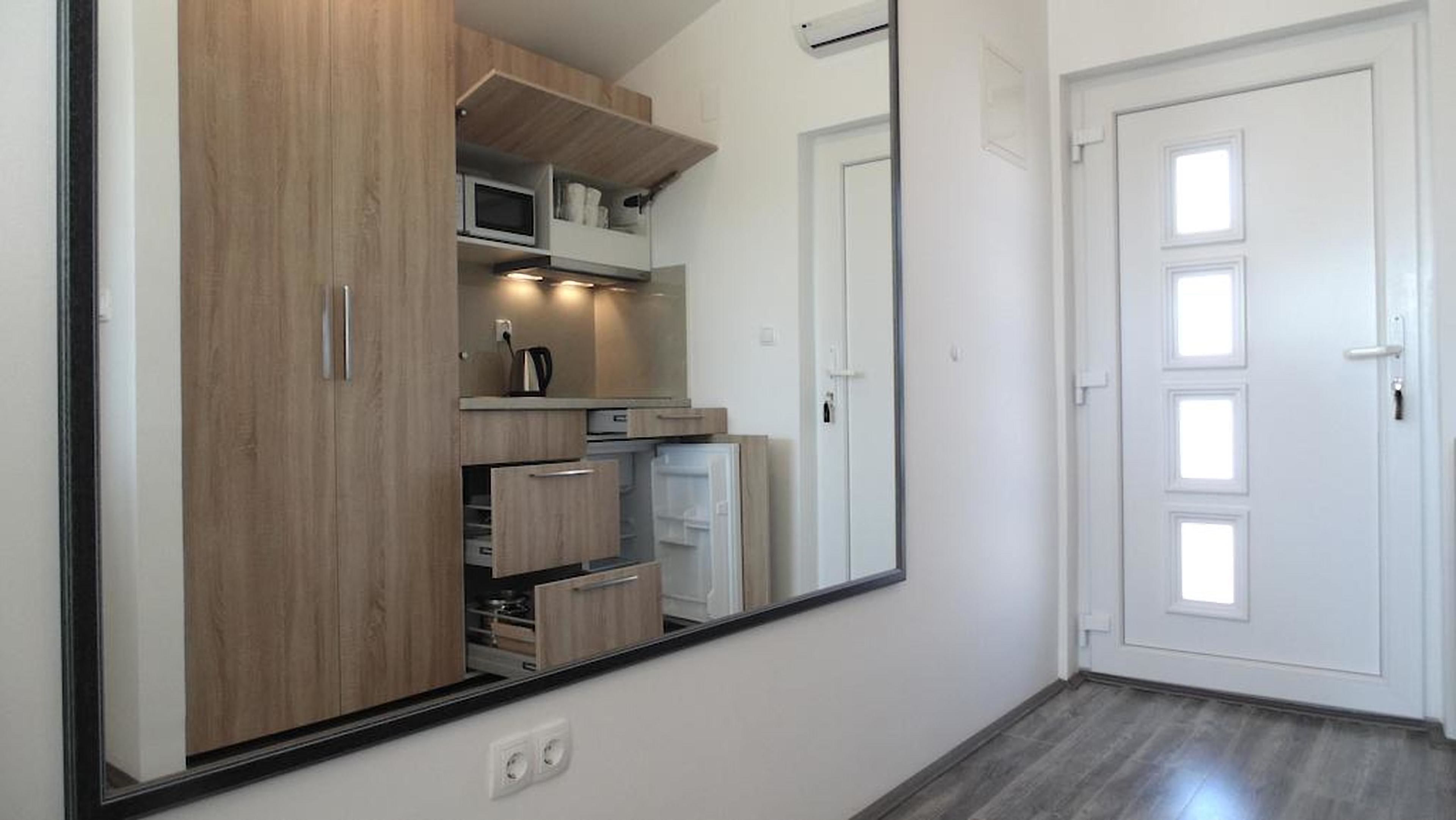 A modern kitchen with wooden cabinets, a microwave, and a refrigerator.