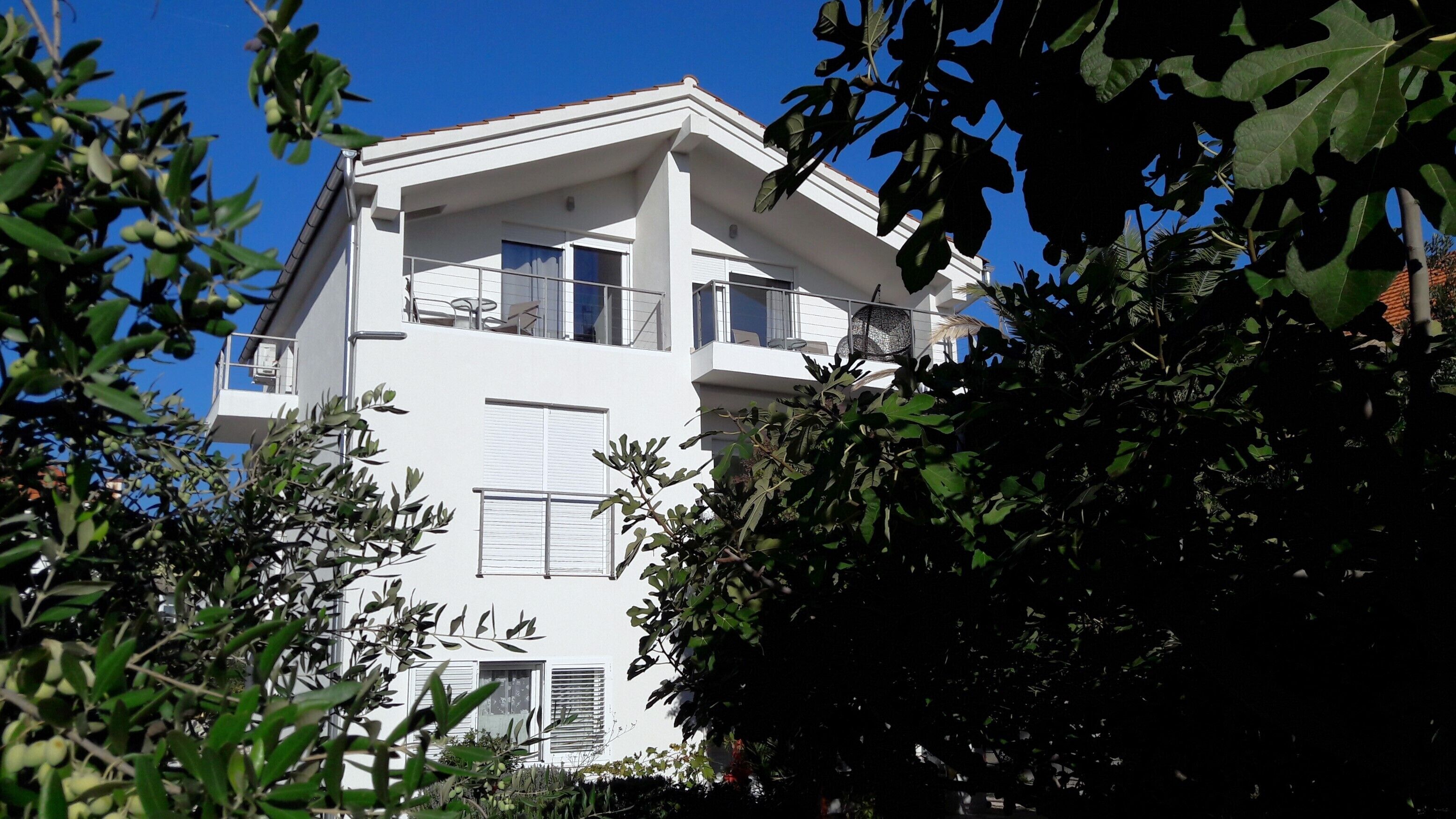 A modern two-story building with balconies and large windows.