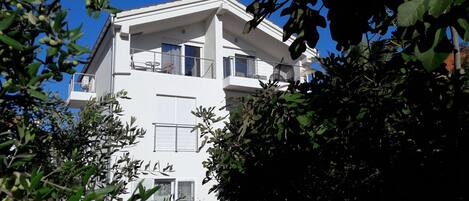 A modern two-story building with balconies and large windows.