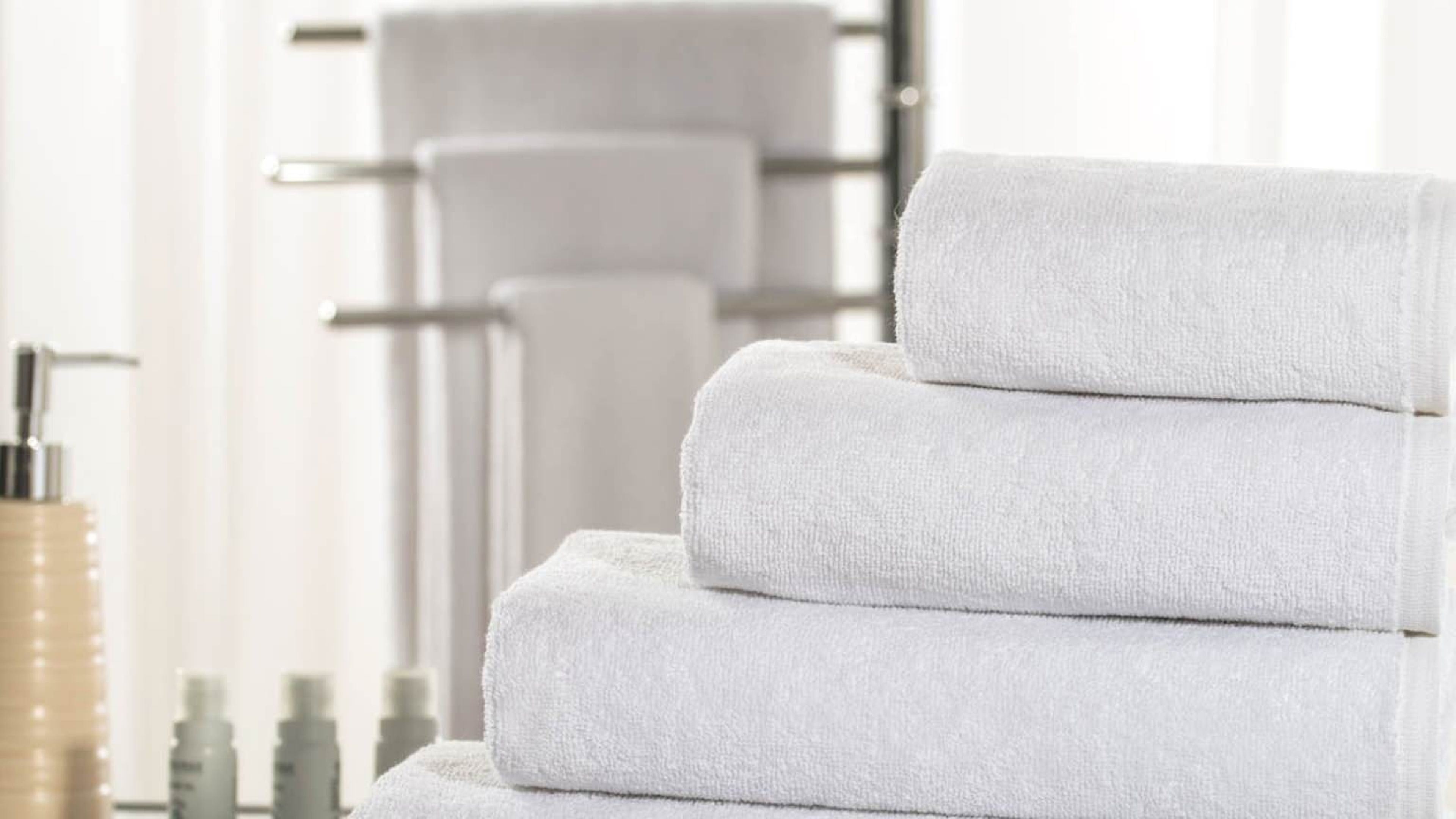 A stack of white towels in a bathroom setting.