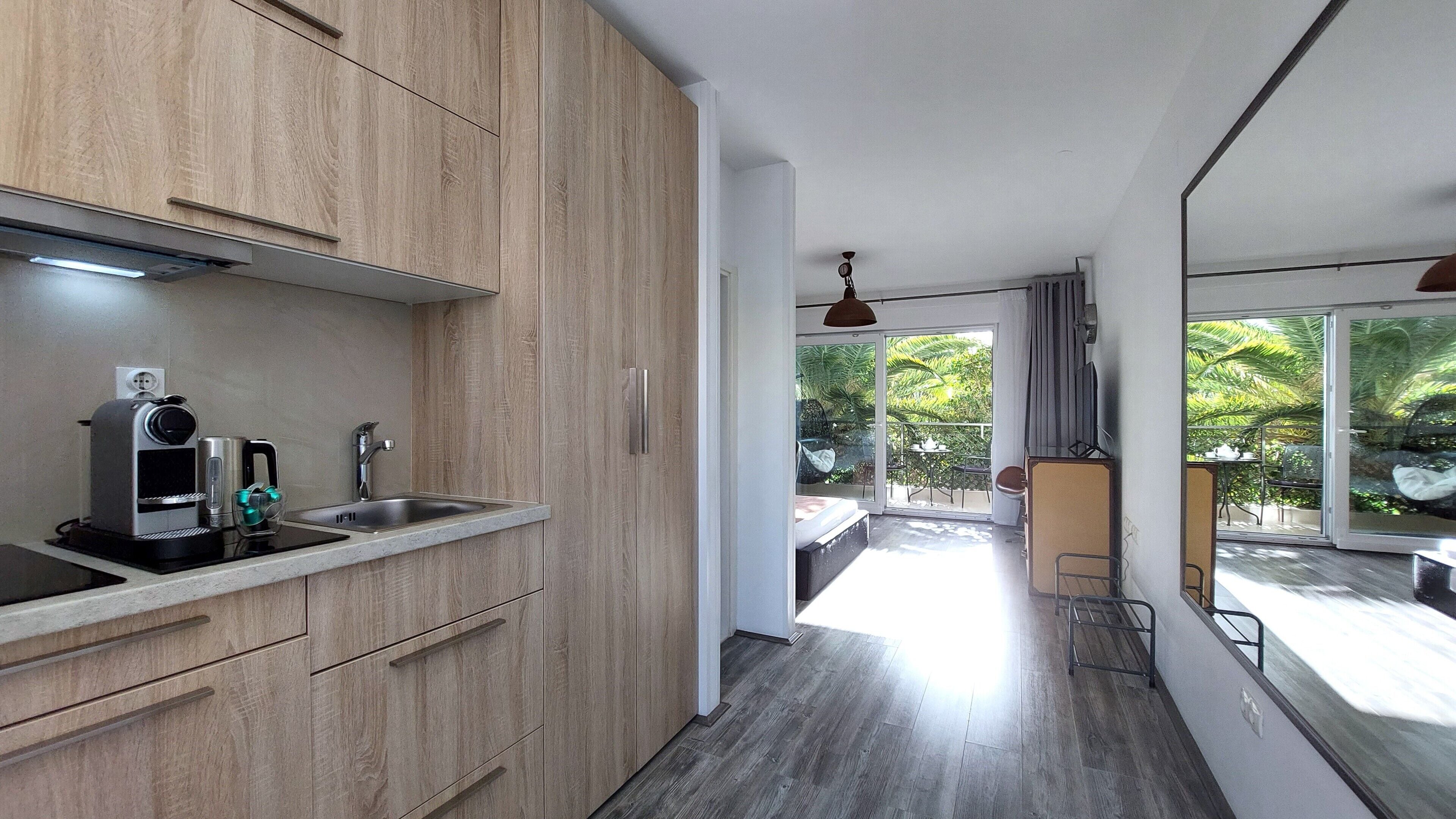 Una cocina moderna con armarios de madera, un lavamanos integrado y una cafetera.
