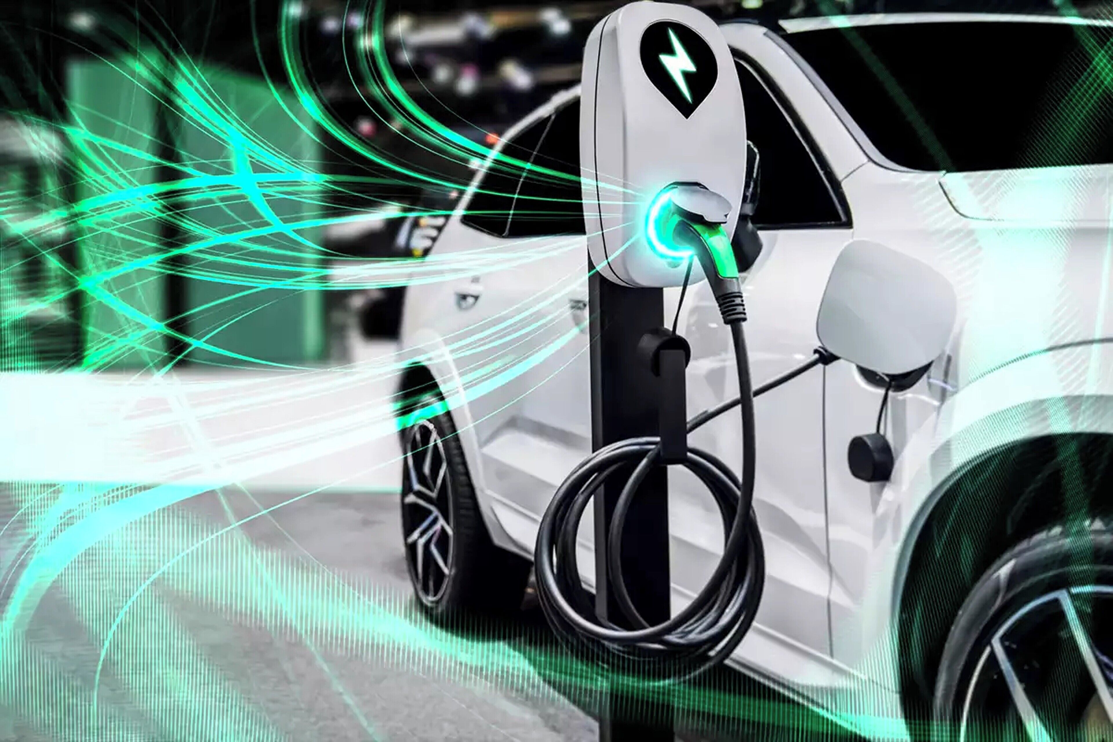 Un vehicle elèctric blanc carregant a una estació amb un endoll brillant.