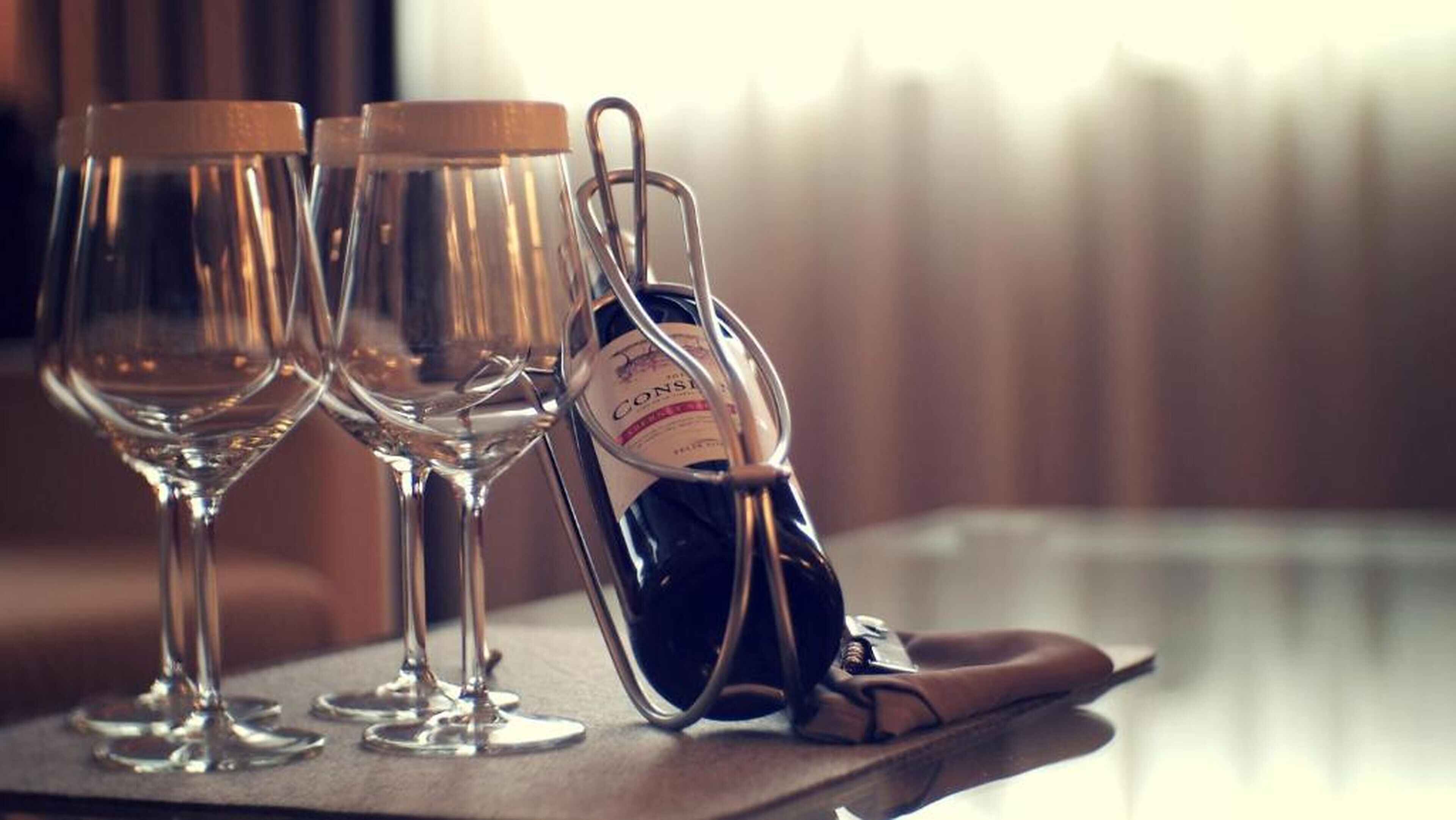 Three wine glasses on a tray, a bottle of wine, and a pair of shoes.