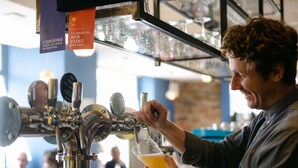 A person pouring beer into a glass at a bar. - Le Lieu Dit (Nantes)