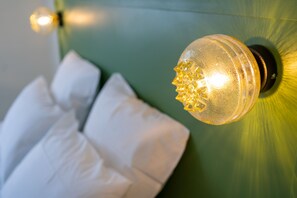 A close-up of a wall-mounted light fixture with a textured glass cover and a visible bulb. - Le Lieu Dit (Nantes)