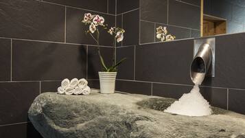 Enjoy a refreshing bathroom experience with a large sink, potted orchid, and convenient hand dryer.