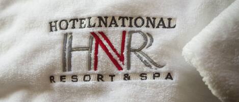 Una toalla con bordado que dice 'HOTELNATIONAL HNR RESORT & SPA'.