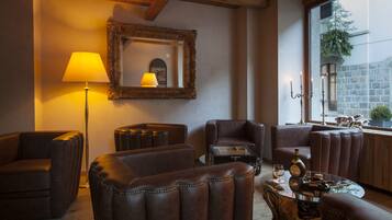 A cozy living room with leather sofas, a glass coffee table, and a lamp.