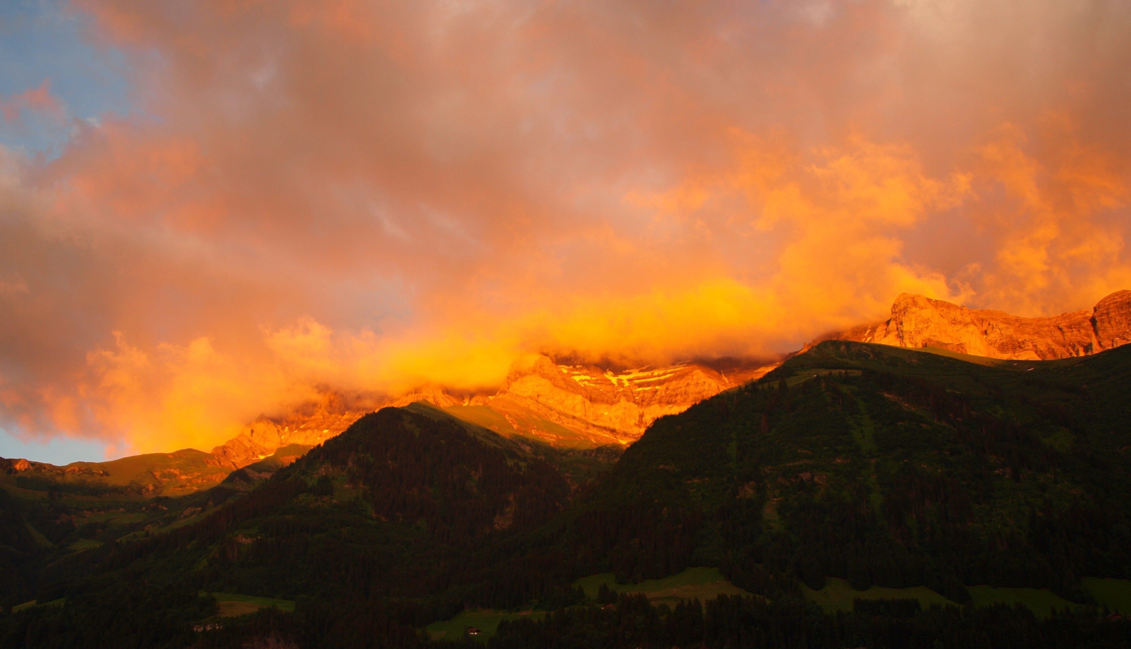 Un paisaje montañoso con un atardecer.