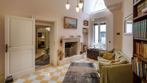 A cozy living room with a checkered floor, a fireplace, a sofa, and a bookshelf. - Palazzo Rollo (Lecce)